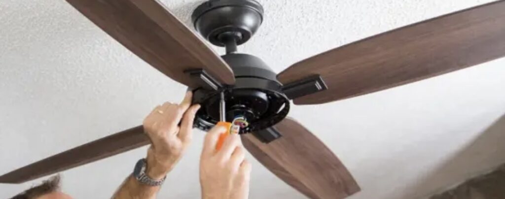 Technician wiring a ceiling fan during installation in a residential Atlanta home