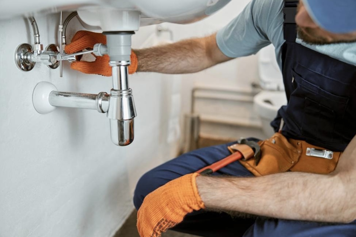 Plumber repairing a bathroom sink drain in Atlanta home